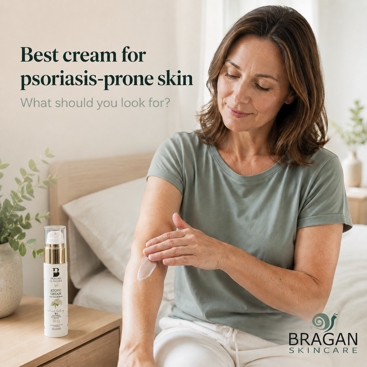 Woman applying moisturiser to dry skin with Bragan Skincare Atopic Cream beside her while considering cream for psoriasis-prone skin.