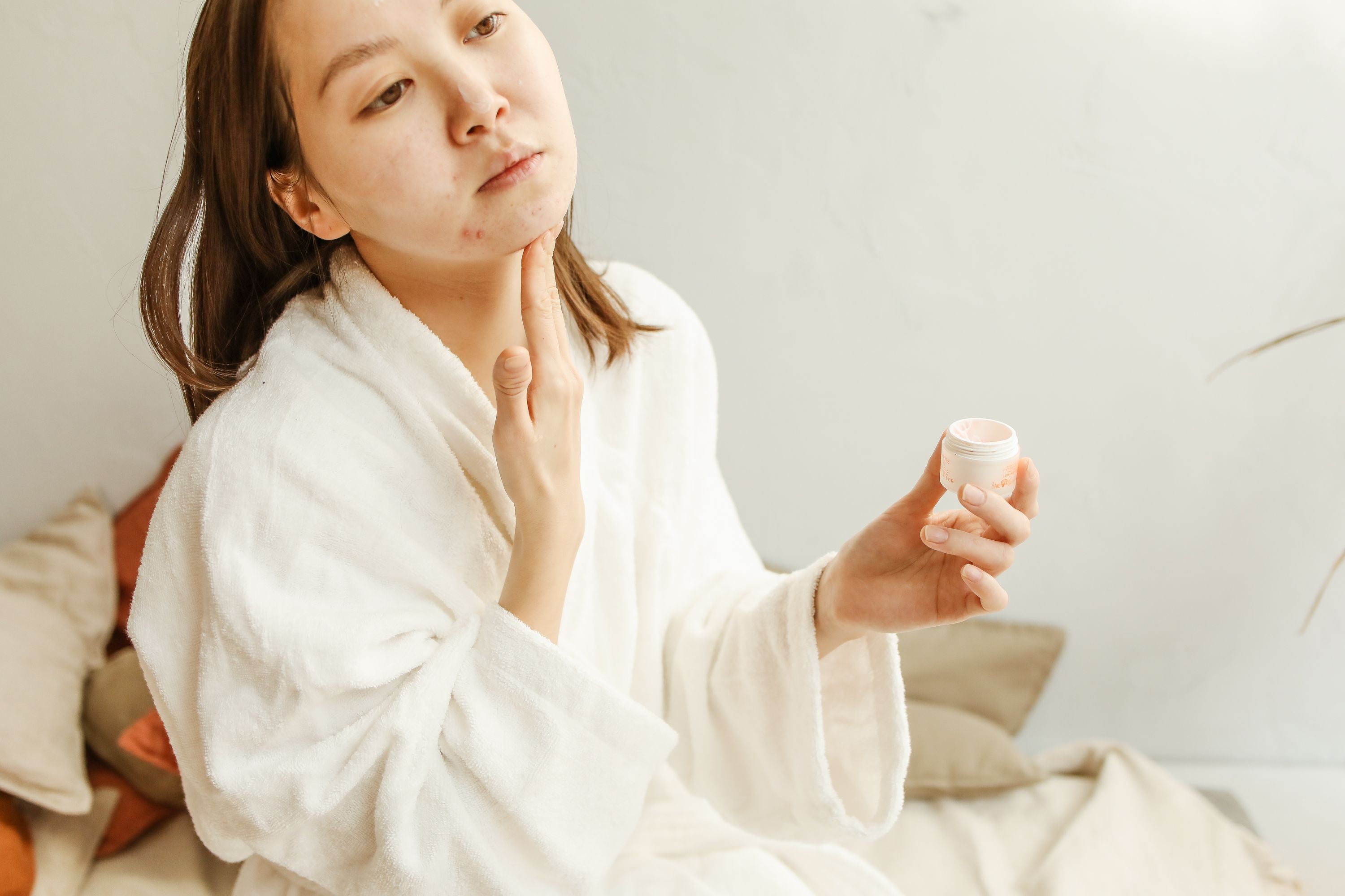 Applying Bragan Skincare Snail Mucin Face Serum to acne-prone skin as part of a gentle skincare routine.