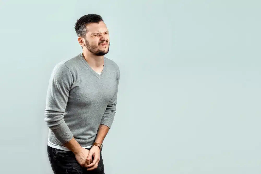 man holding his groin area with eczema