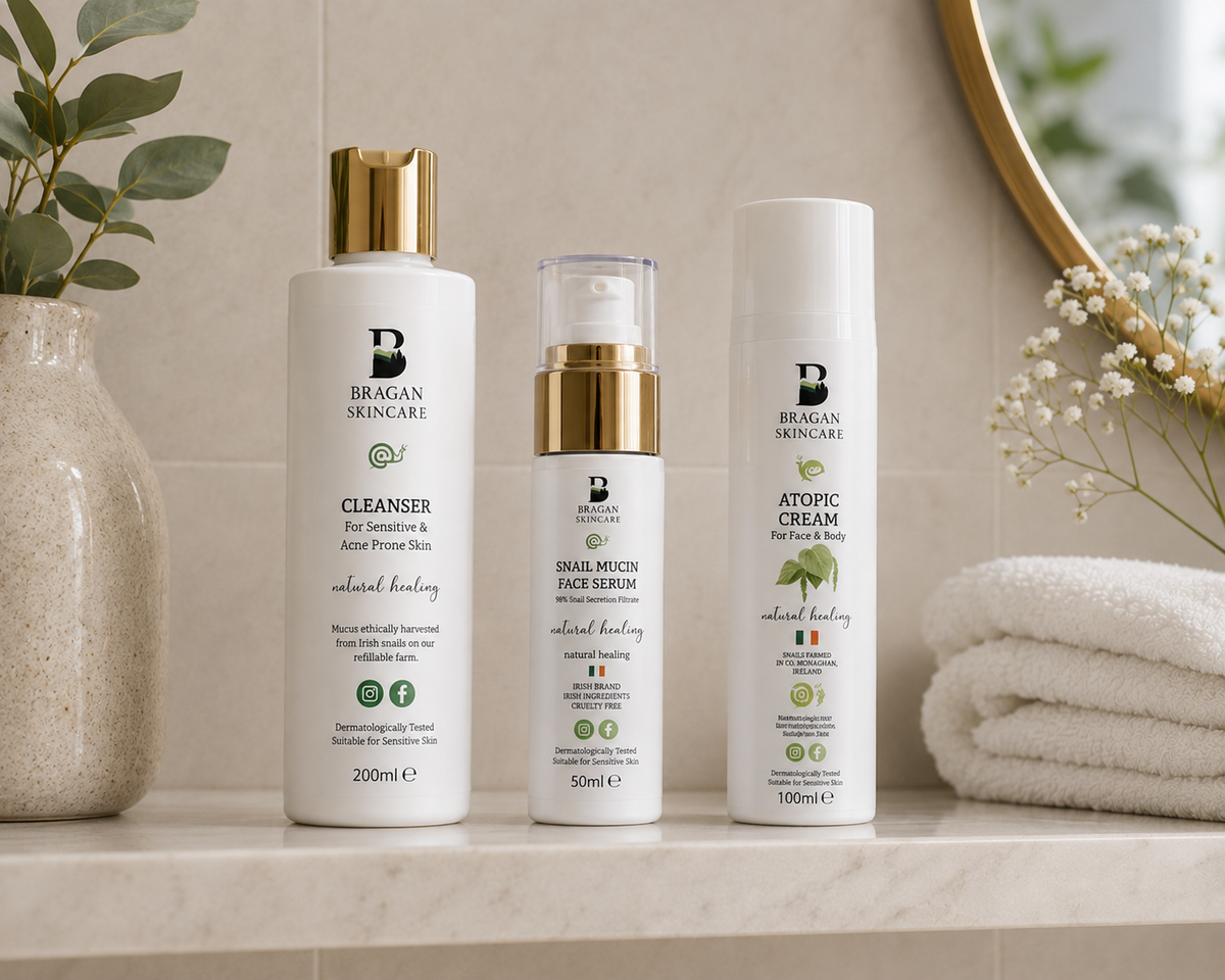 Bragan Skincare cleanser, snail mucin face serum and Atopic Cream displayed on a bathroom shelf