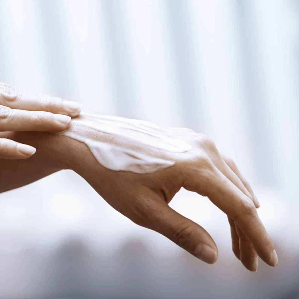 Hands applying hand cream