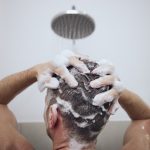 person washing hair while treating scalp psoriasis