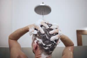 person washing hair while treating scalp psoriasis