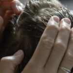 a mother examines her daughter's sensitive scalp